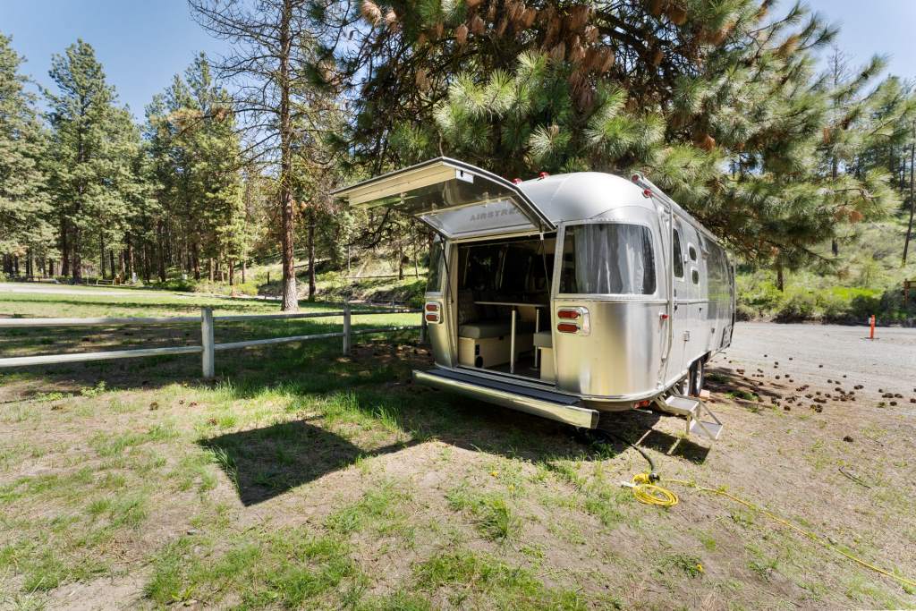 Vintage Airstream Flying Cloud parked at a scenic campsite.